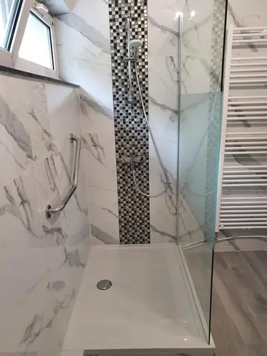 Douche vitrée en carrelage effet marbre blanc avec frise verticale en mosaïque
