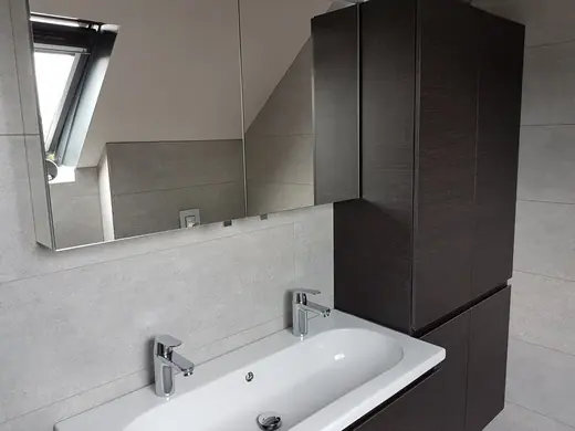 Meuble de salle de bains gris avec double vasque, robinets chromés et grand miroir