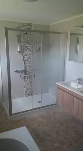 Douche avec parois vitrées, bande décorative en mosaïque et meuble de salle de bains